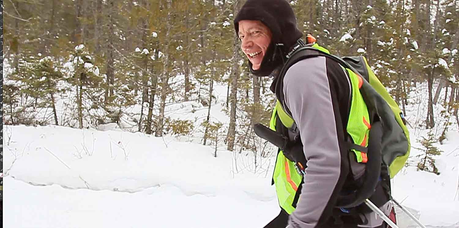 A man in the snow with a backpack.