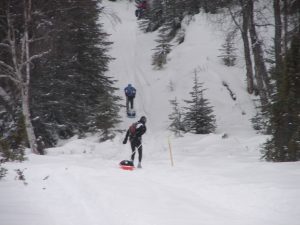 Two people on snow boards in the snow.