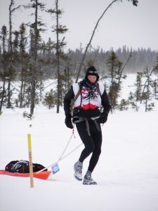 A person on skis in the snow near trees.