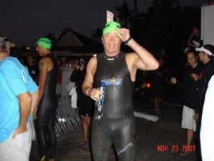 A man in a wetsuit and green hat