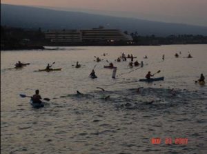 A group of people in kayaks paddling across the water.