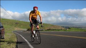 A man riding a bike down the middle of a road.