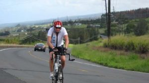 A man riding a bike down the middle of a road.