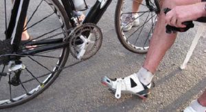 A person standing next to two bicycles on the street.