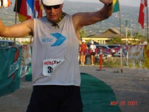 A man in white shirt and black shorts running.